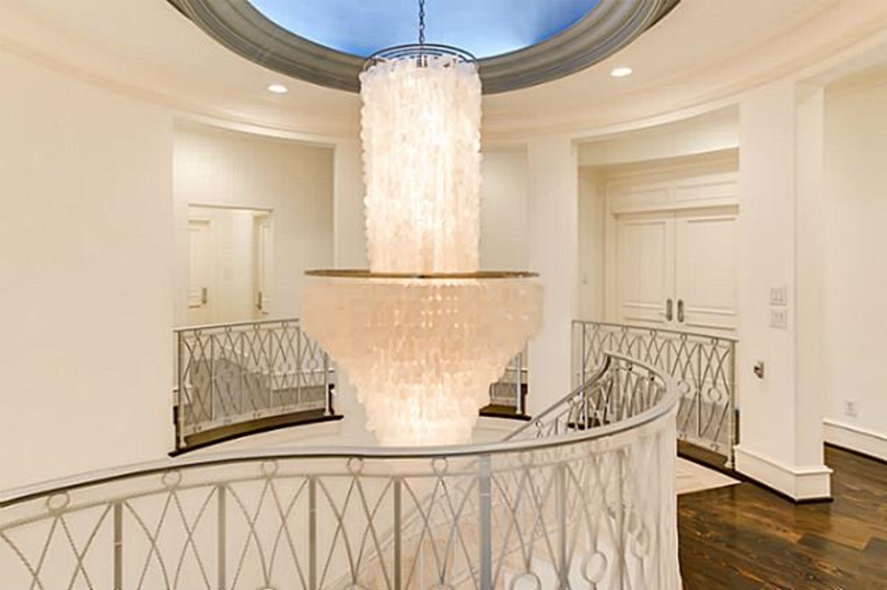 A large chandelier hangs over the main stairwell.