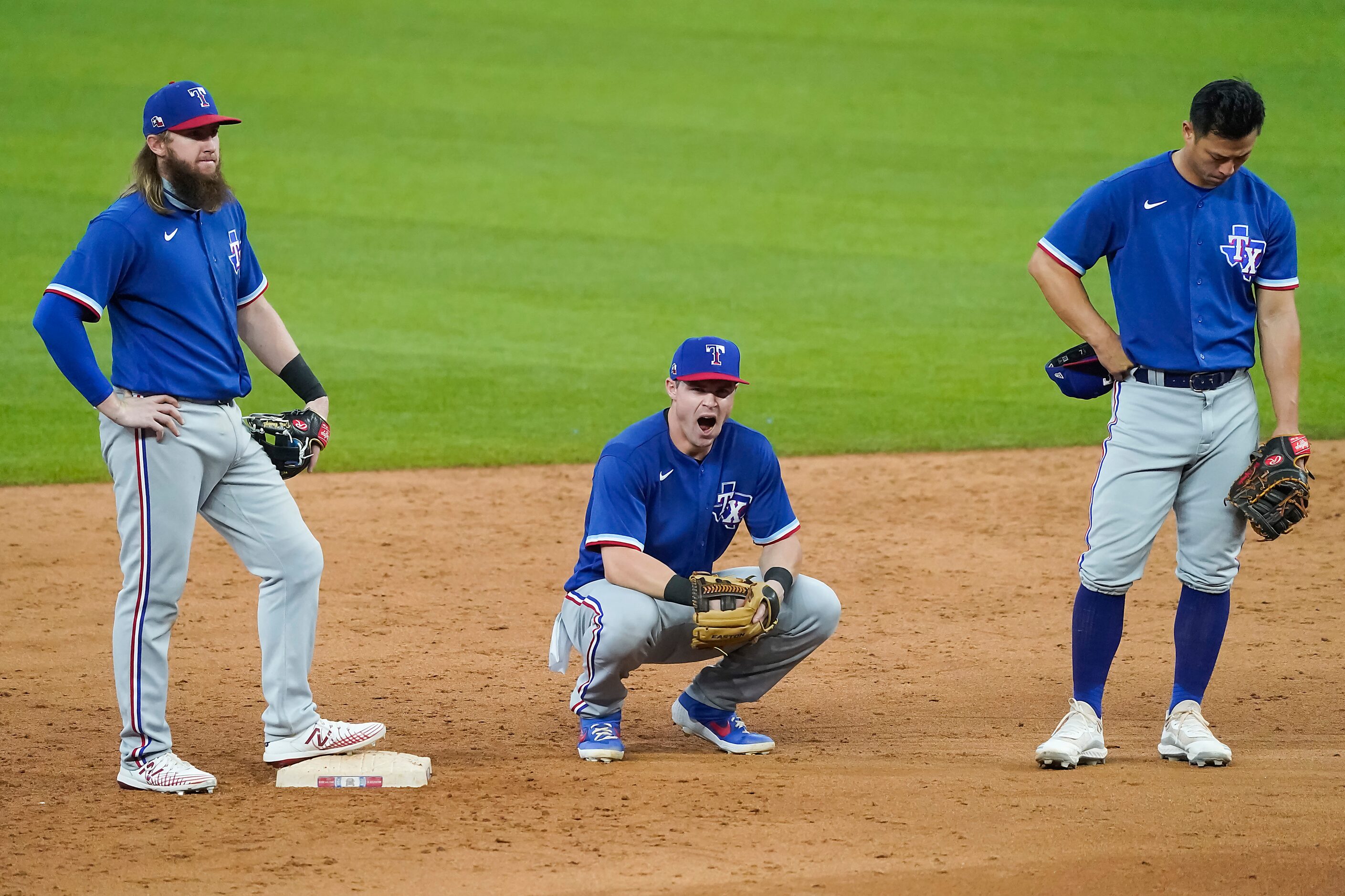 Texas Rangers outfielder Scott Heineman (center), who was playing second base at the time,...