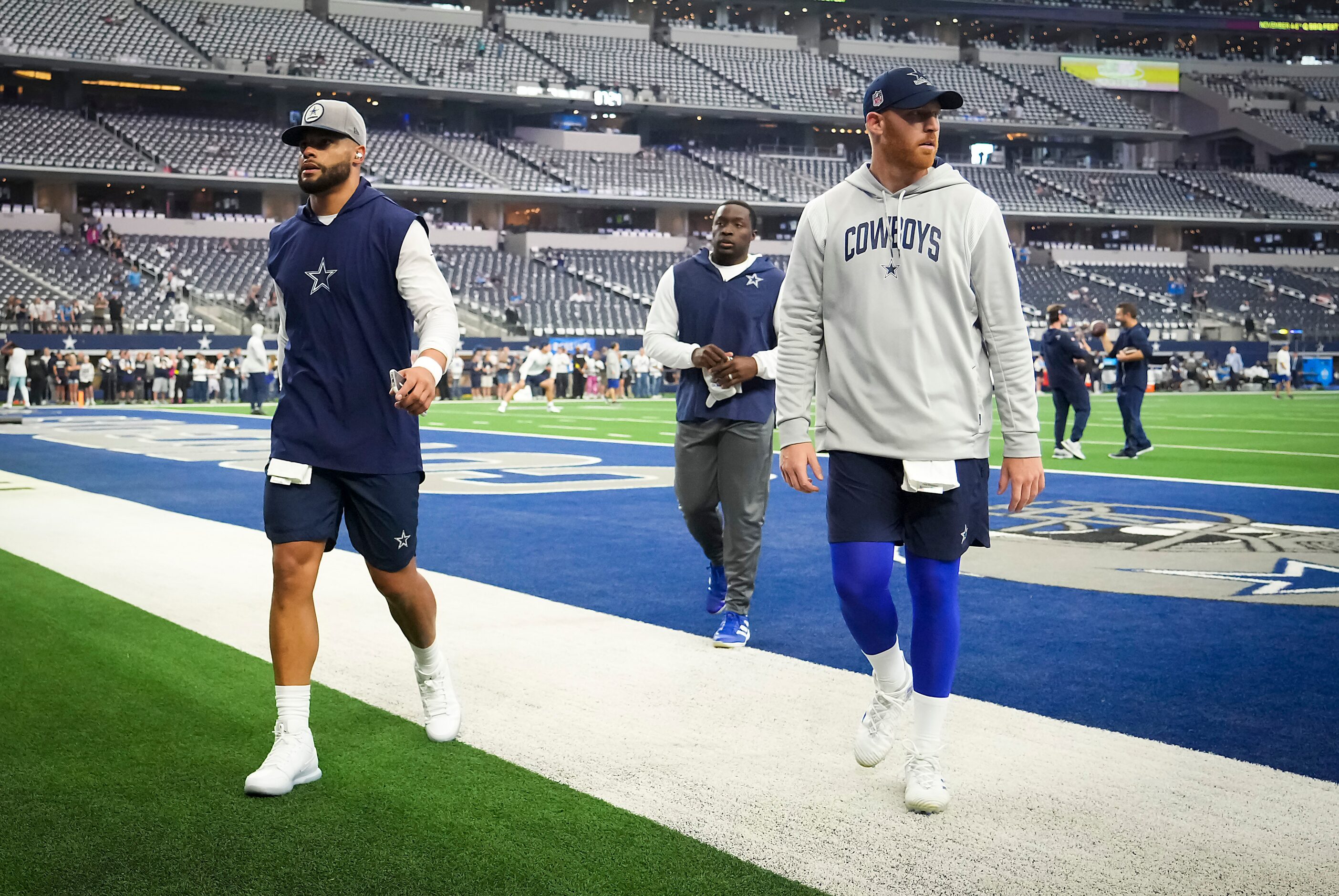 Dallas Cowboys quarterback Dak Prescott (left) and quarterback Cooper Rush walk off the...