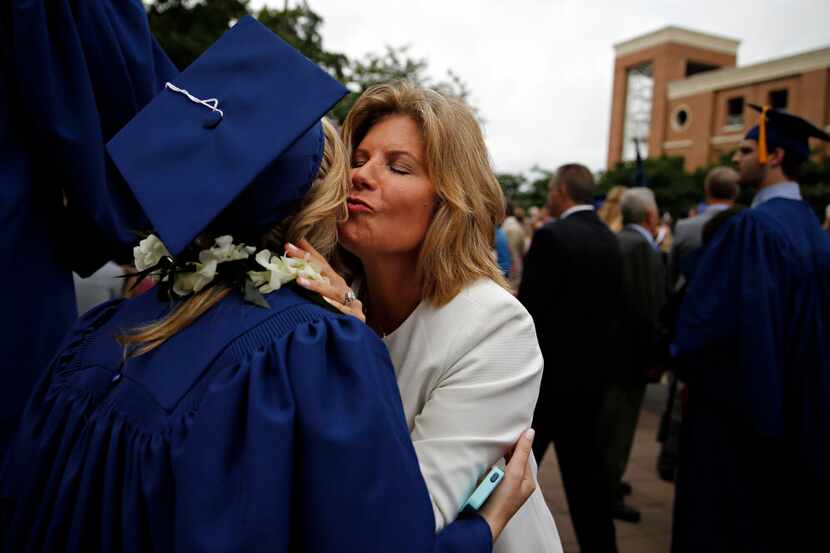 Autumn Goerke (center) hugs her daughter, graduate Taylor Goerke, following the SMU May...