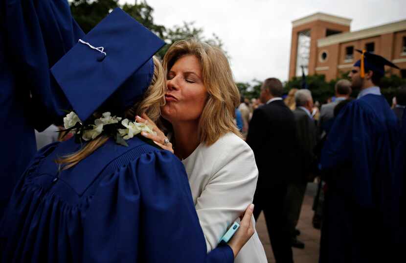 Autumn Goerke (center) hugs her daughter, graduate Taylor Goerke, following the SMU May...