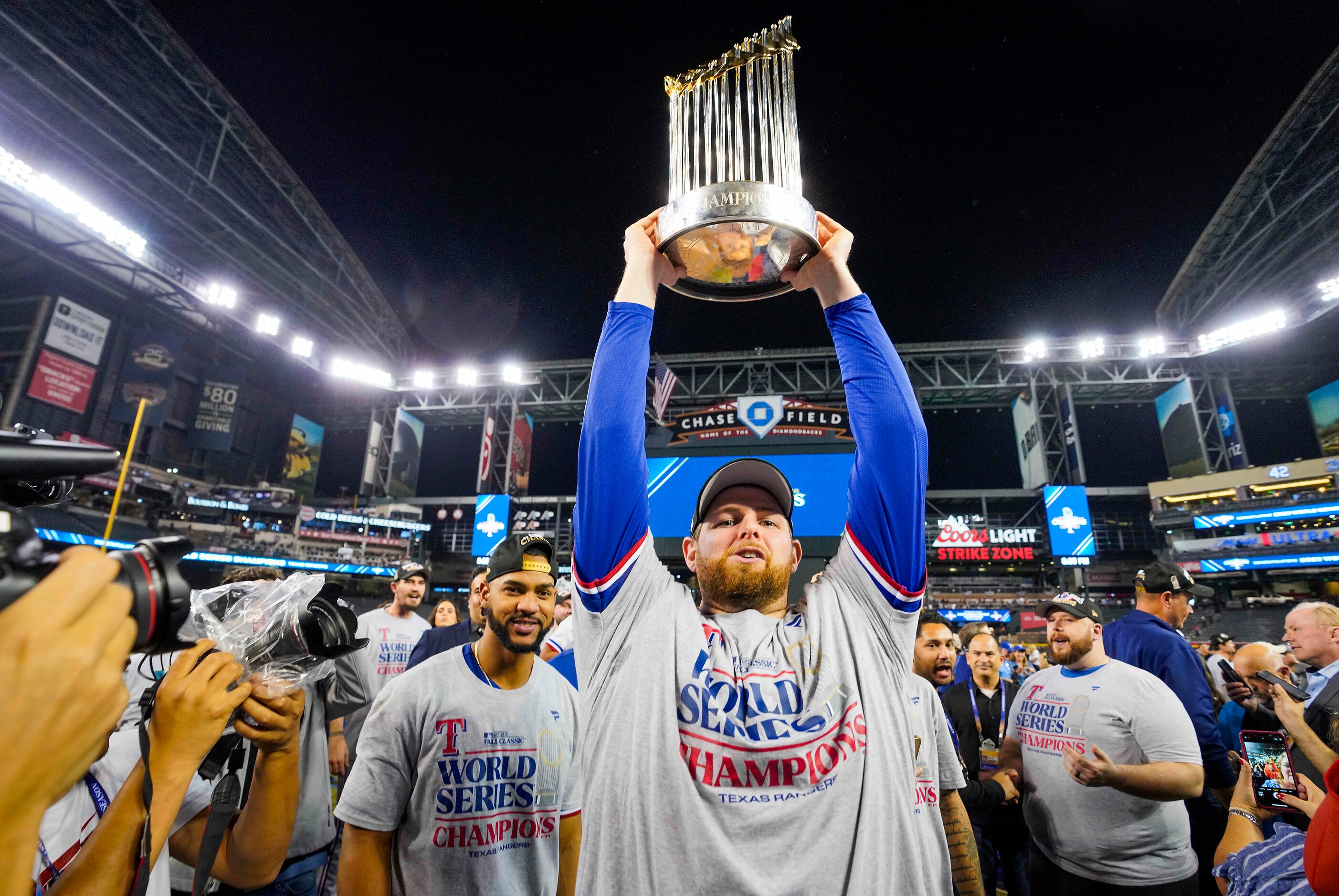 Texas Rangers starting pitcher Jordan Montgomery hoists the the Commissioners Trophy for...