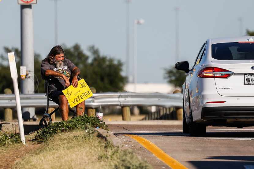 A panhandler on an I-30 exit ramp on Cockrell Hill Road in Dallas on Wednesday, Oct. 26, 2022.