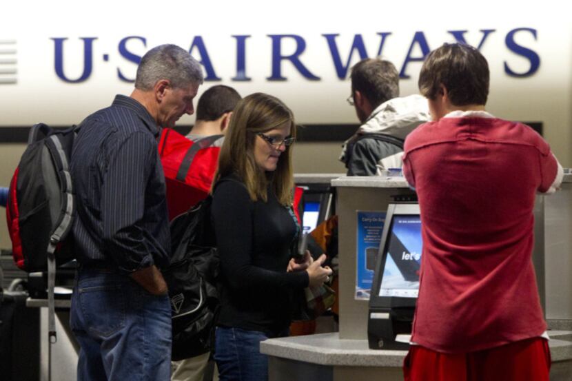 Brian Hoffer and his wife, Pam, check in for a US Airways flight. The Tempe, Ariz.-based...