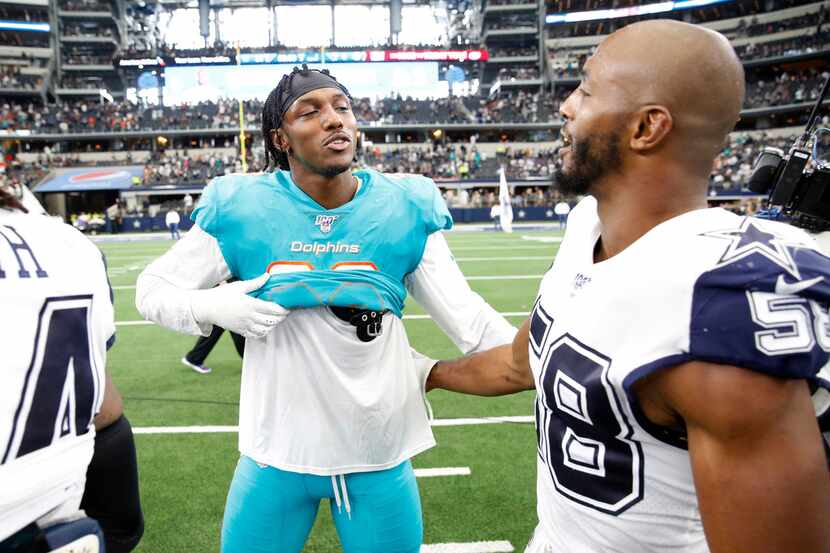 Miami Dolphins Taco Charlton (96) talks with Dallas Cowboys defensive end Robert Quinn (58)...