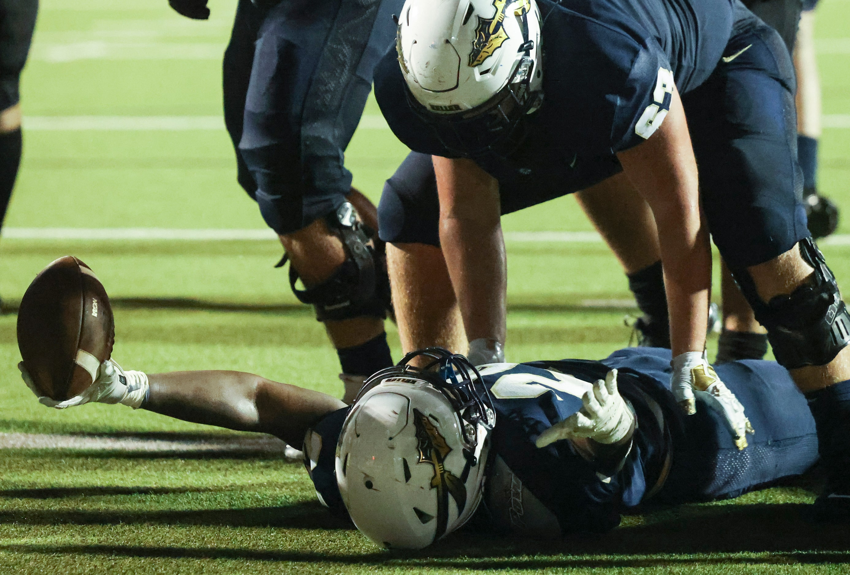 Keller High School Tex Mahon (63) celebrates with Cameron Rayford (24) as he scores a...