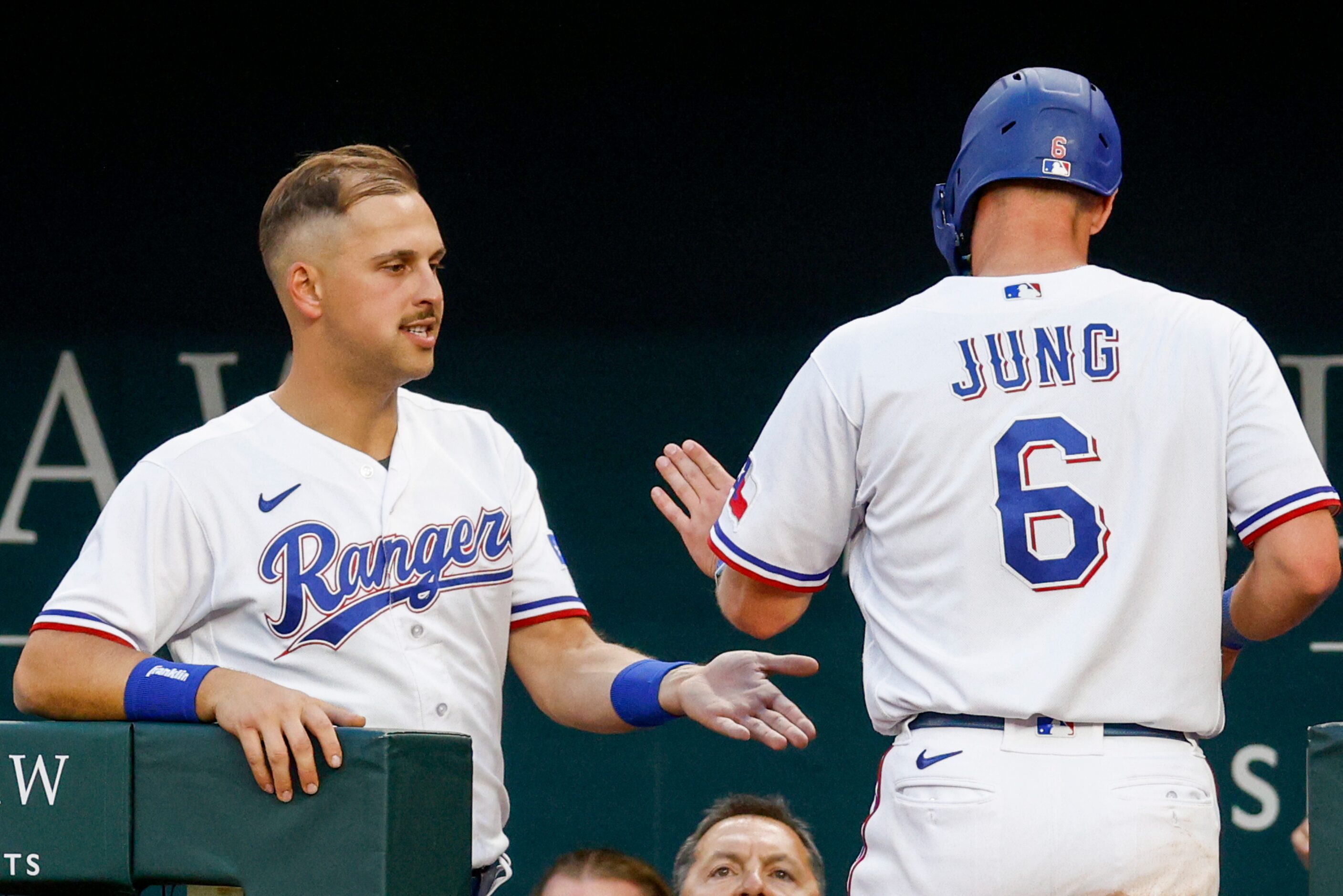 Texas Rangers third baseman Josh Jung (6) high-fives first baseman Nathaniel Lowe (30) after...