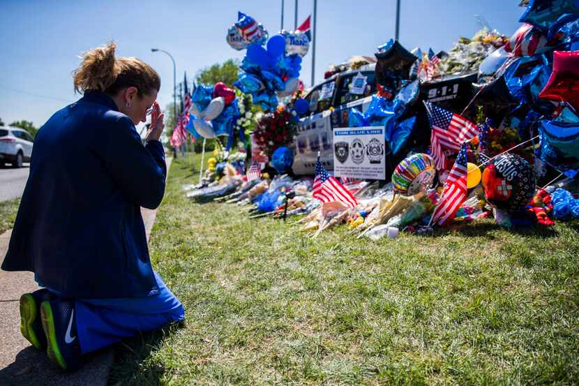 Shari Stout prayed next to a makeshift memorial for Dallas police Officer Rogelio Santander...