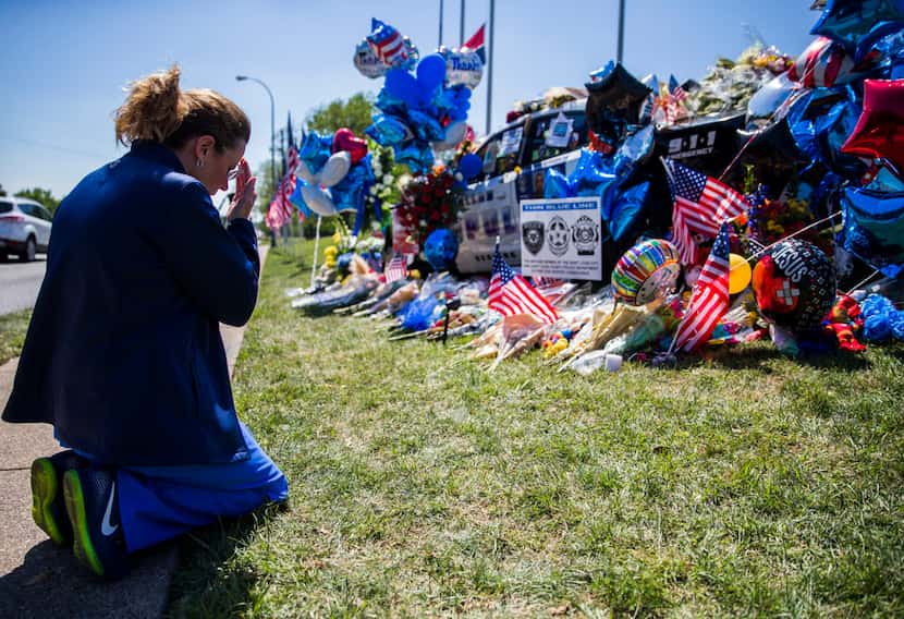 Shari Stout prayed next to a makeshift memorial for Dallas police Officer Rogelio Santander...