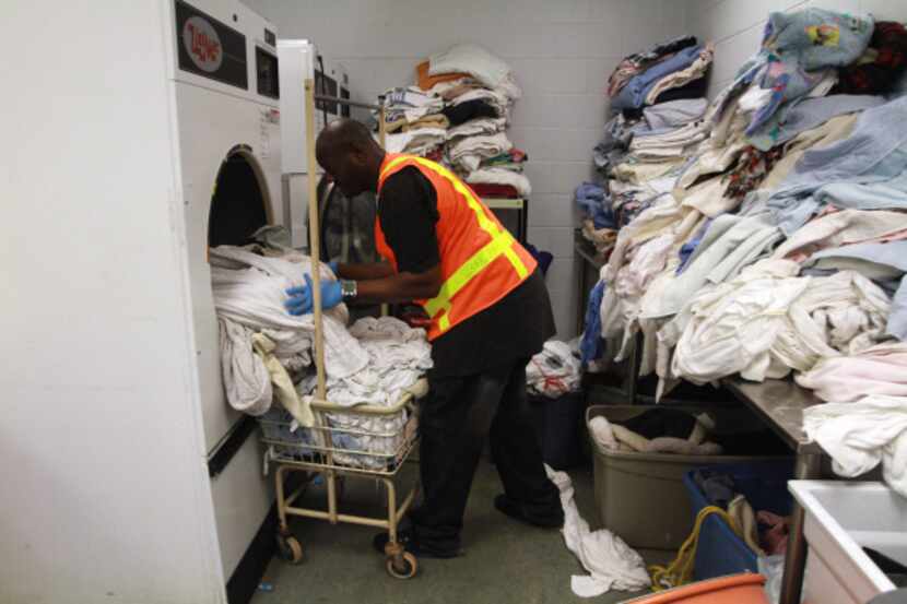 Temporary employee Antwone Barber, 35, loaded wet towels and blankets on Friday, his first...