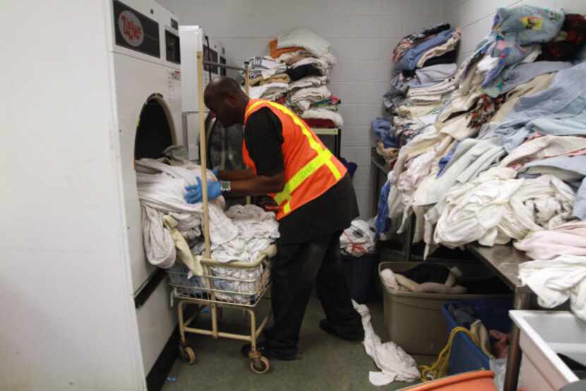 Temporary employee Antwone Barber, 35, loaded wet towels and blankets on Friday, his first...