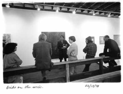 A group of gallery members leans and sits against a railing inside 500X Gallery in 1978, the...