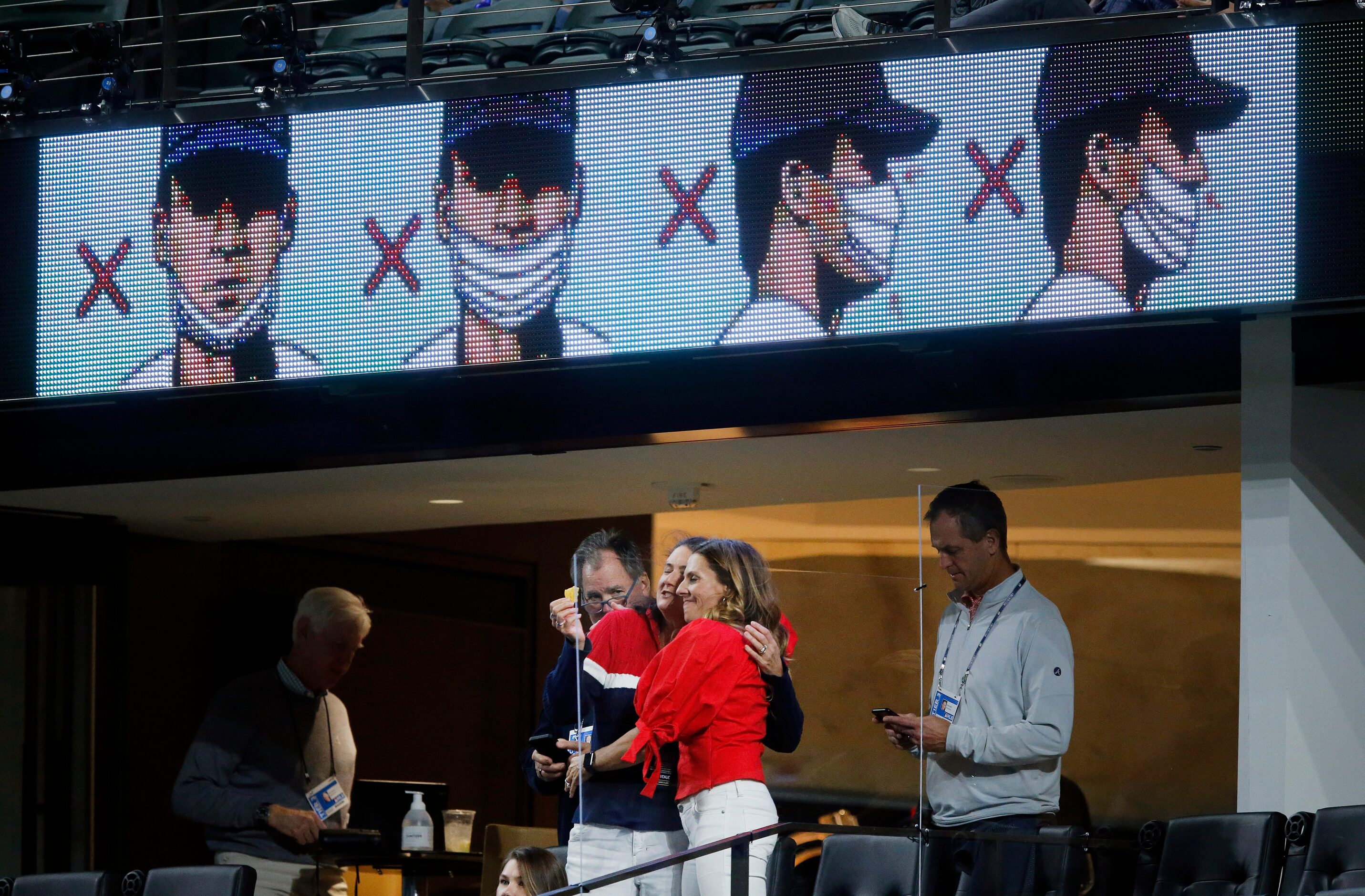 Maskless Atlanta Braves fans hug one another during the eighth inning in Game 4 of the...