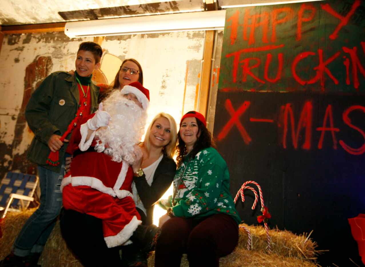 Eddie Zannetti, as Santa, sits on Kelly Dlabaj's lap as she's photographed with a group of...