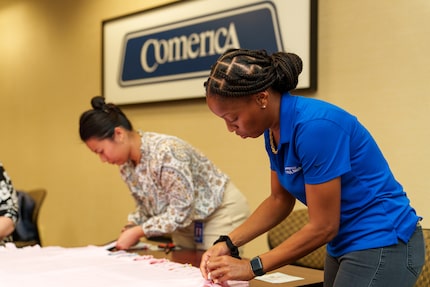 Two women work on creating a quilt.