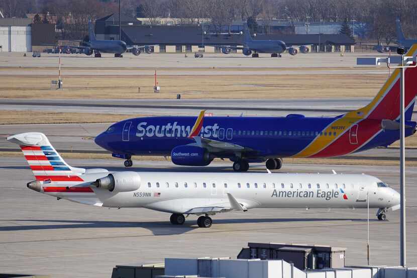 A Southwest Airlines Boeing 737 and an American Eagle Bombardier CRJ pass each other on the...