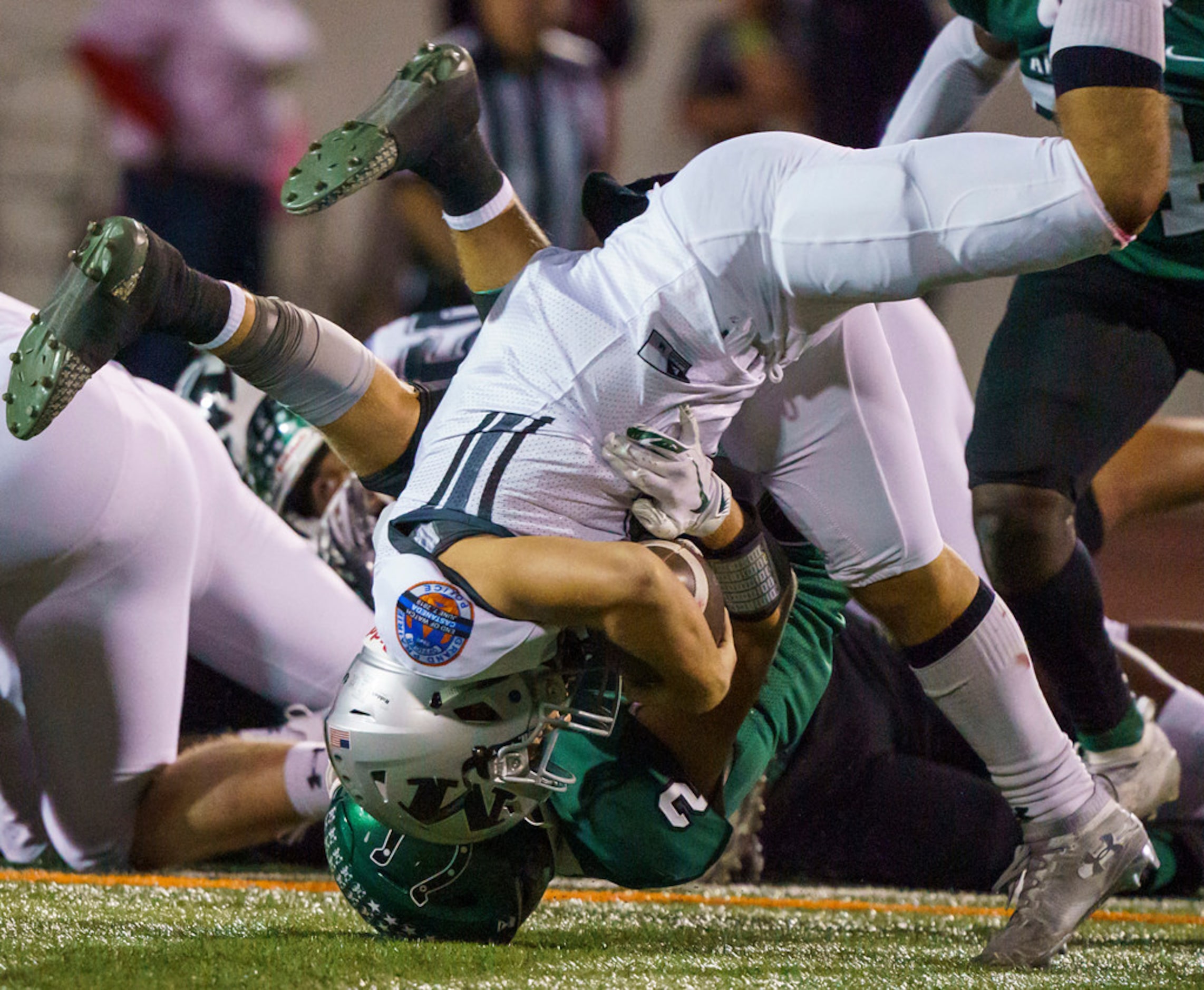 Arlington Martin quarterback Zach Mundell (6) is brought down by Arlington defensive back...