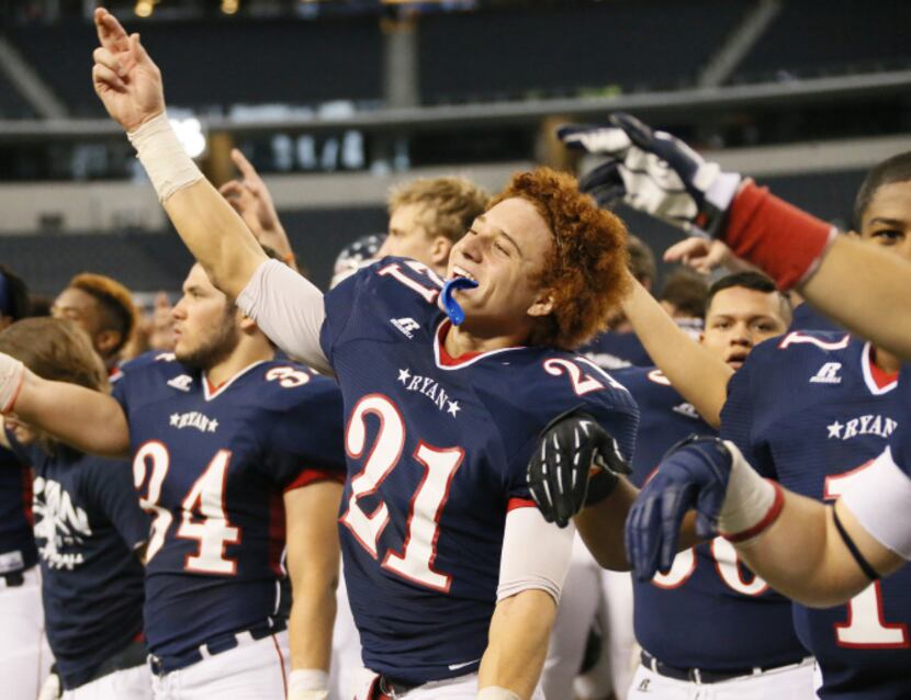 Denton Ryan's Trent Willis (21) celebrates with teammates after the Raiders' 34-33 win...