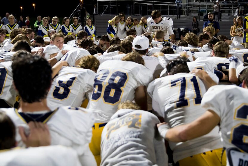 Highland Park Scots players pray after their loss against Wylie East High School at Wylie...