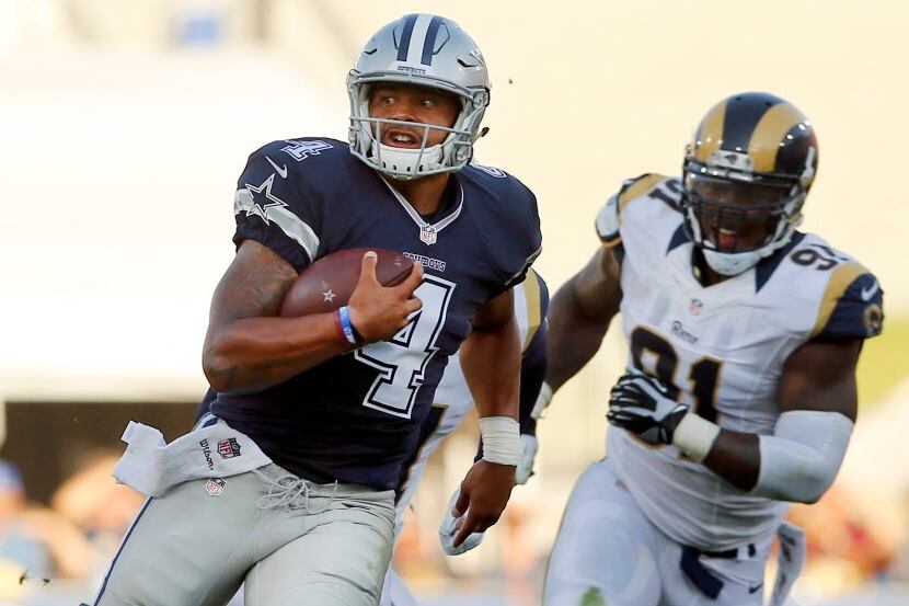 Dallas Cowboys quarterback Dak Prescott (4) keeps the ball and rushes past Los Angeles Rams...