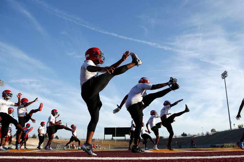 The Carter High School football team stretches during practice at Kincaide Stadium in...