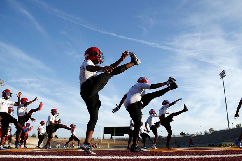 The Carter High School football team stretches during practice at Kincaide Stadium in...