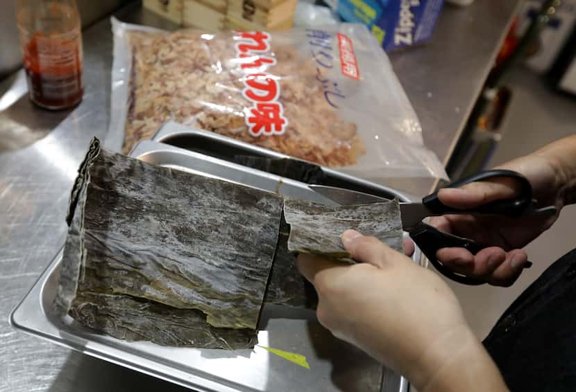 Chef Koji Yoshida demonstrates the process of cutting kombu for making dashi at Ebesu in Plano.