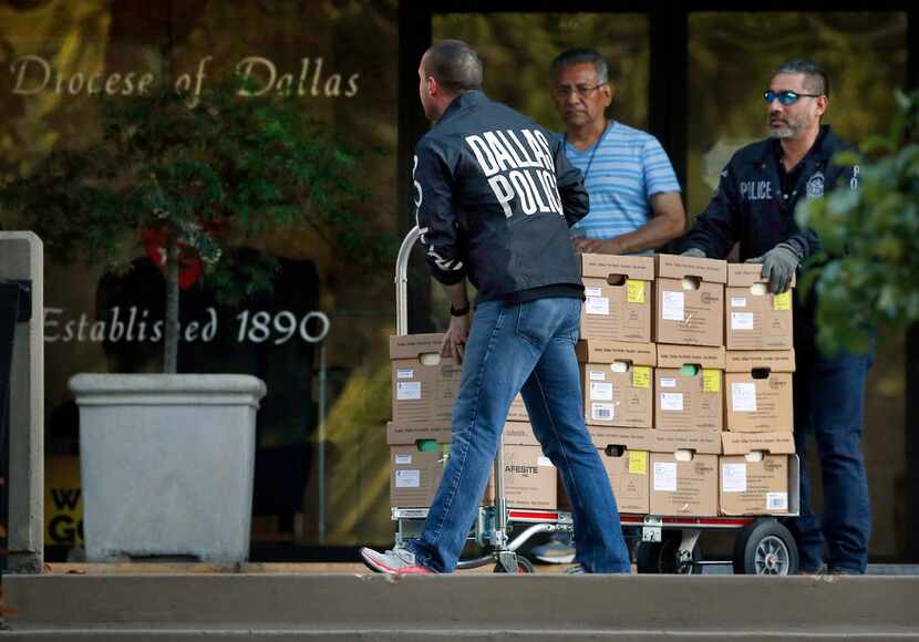 Dallas police officials cart out boxes from a raid on the Catholic Diocese of Dallas on May 15.