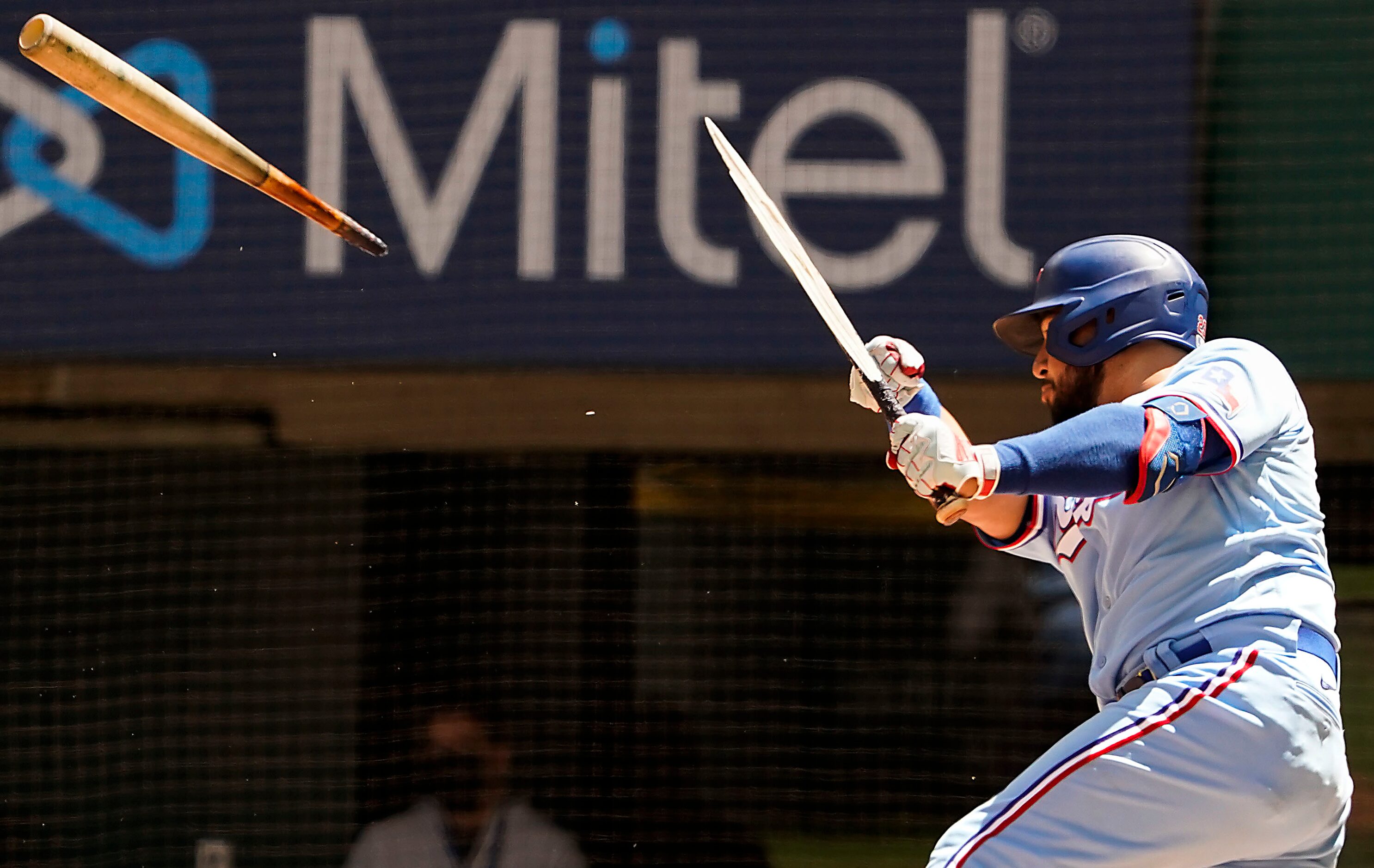 Texas Rangers catcher Jose Trevino breaks his bat as he flies out to right field during the...