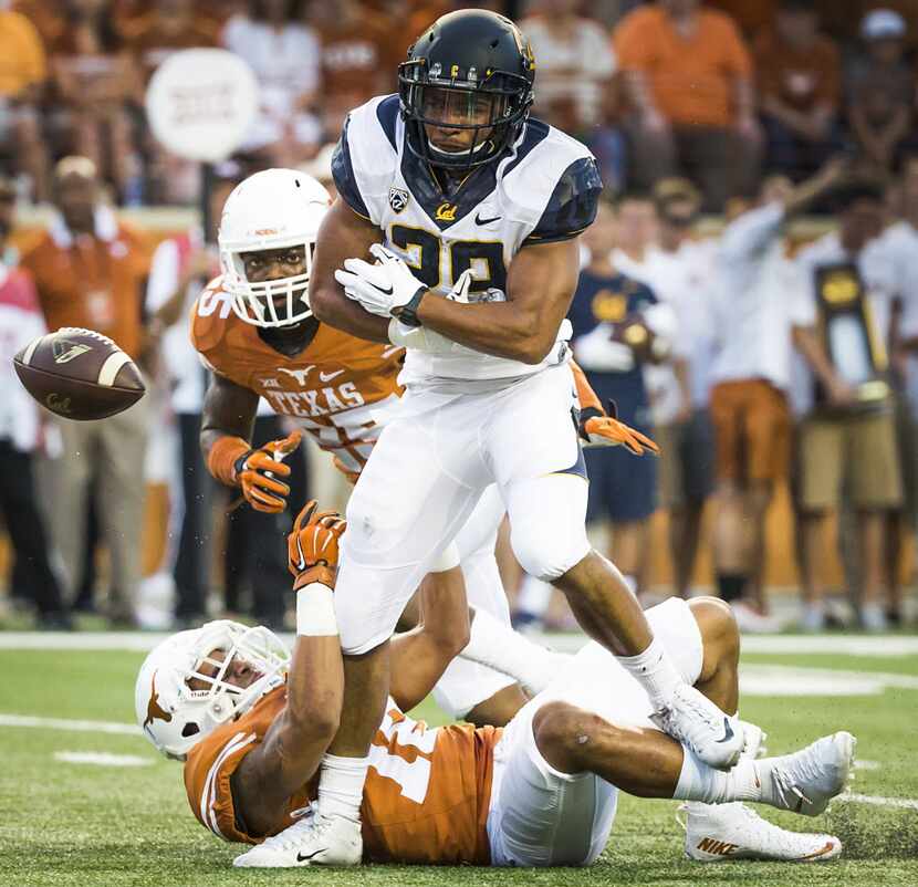 California running back Khalfani Muhammad (29) loses the ball as he is hit by Texas safety...