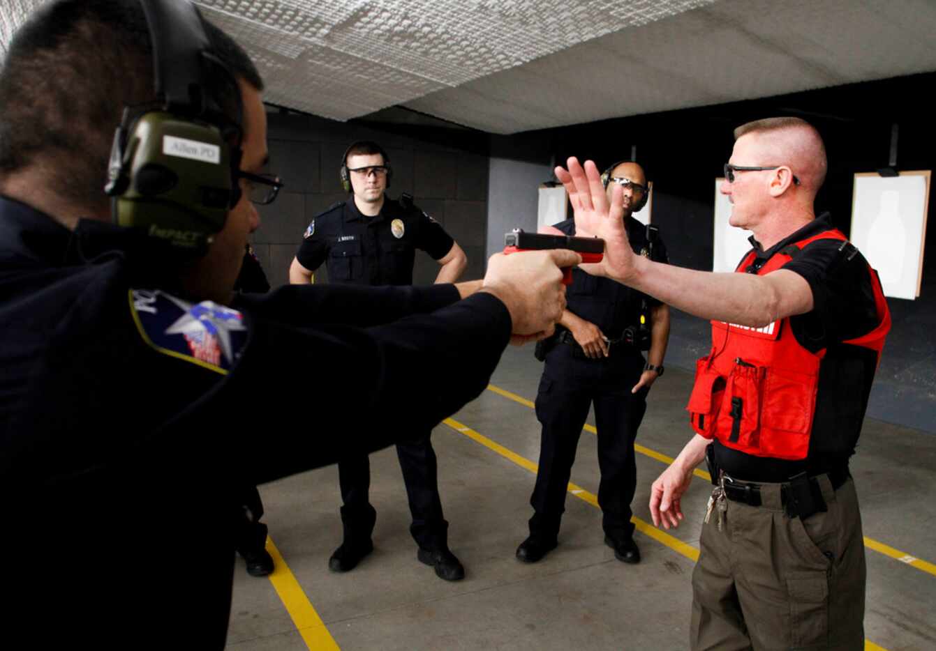 Ricky Pollan, range master of the Allen Police Department, uses a training pistol to show...