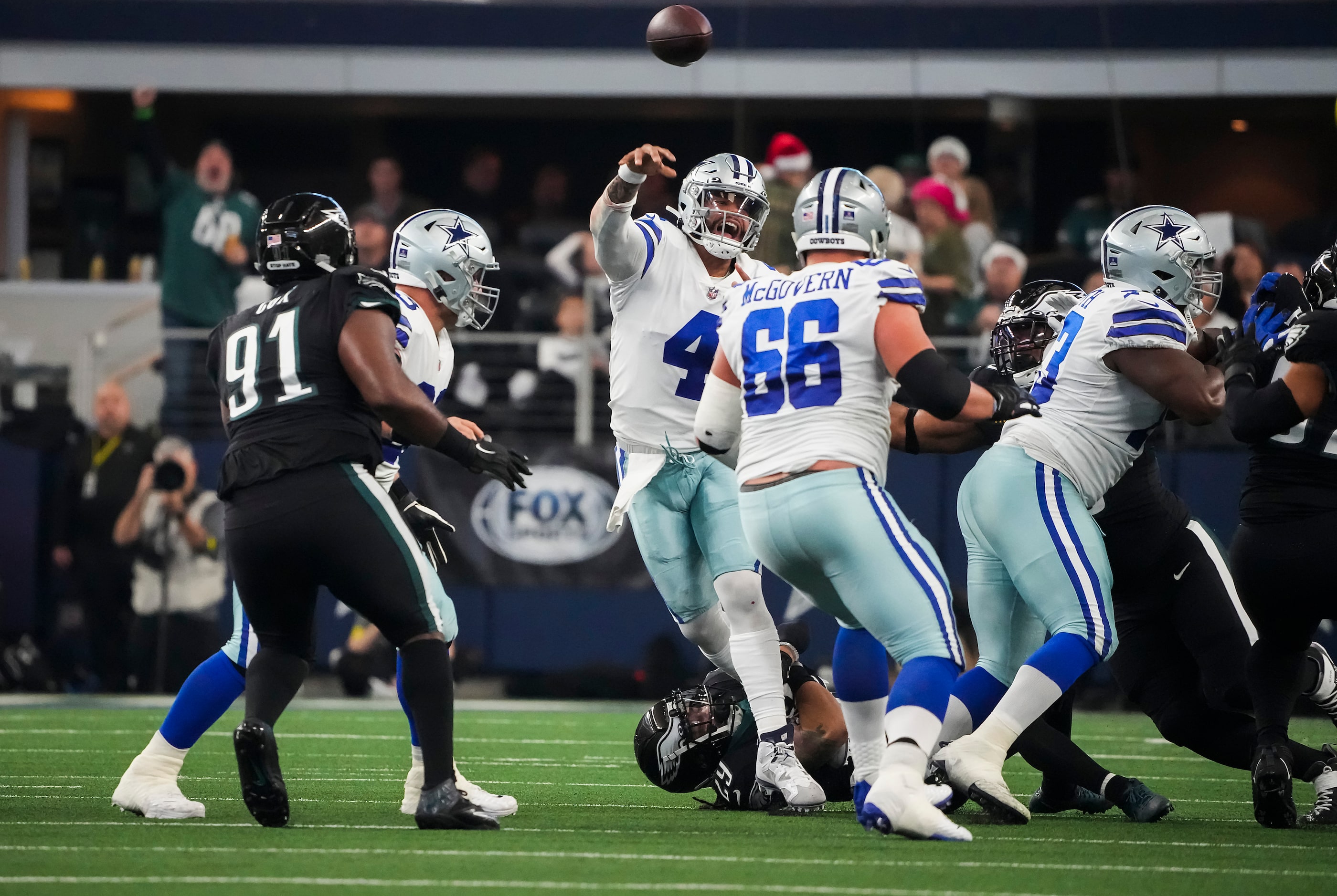 Dallas Cowboys quarterback Dak Prescott (4) throws a pass as he is nearly sacked by the...