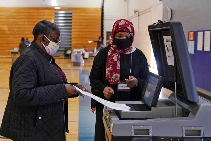 Election judge Naima Hussen watched as Elizabeth Boykin cast her ballot at North High School...