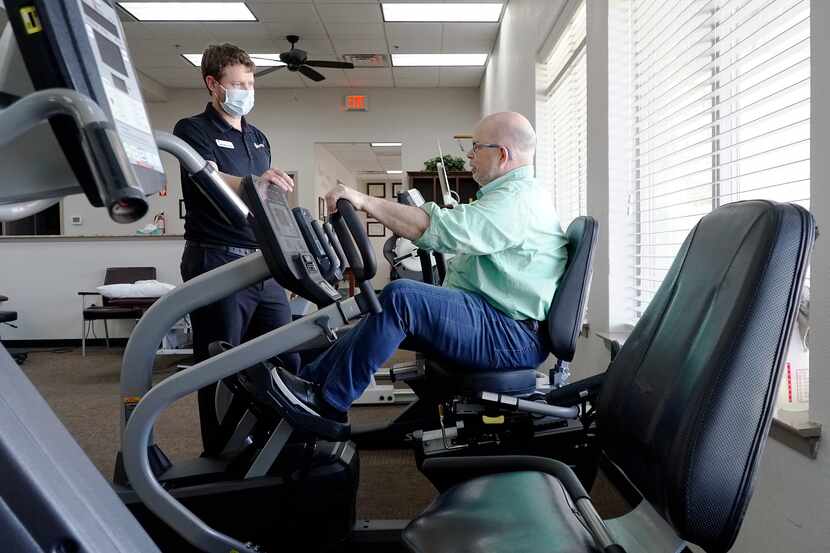 Dr. Brandon O’Malley demonstrates exercises with former patient Scott Amon at SporTherapy in...