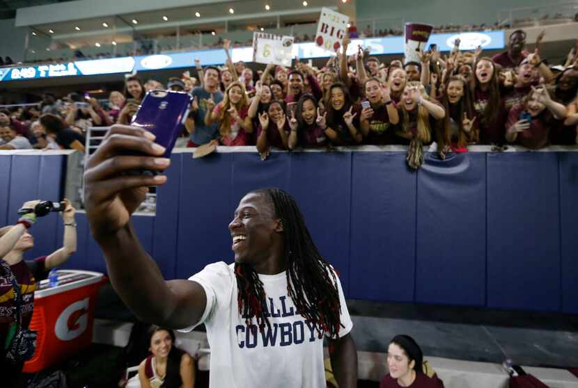 Dallas Cowboys wide receiver Lucky Whitehead laughs as he takes photos with fans during a...