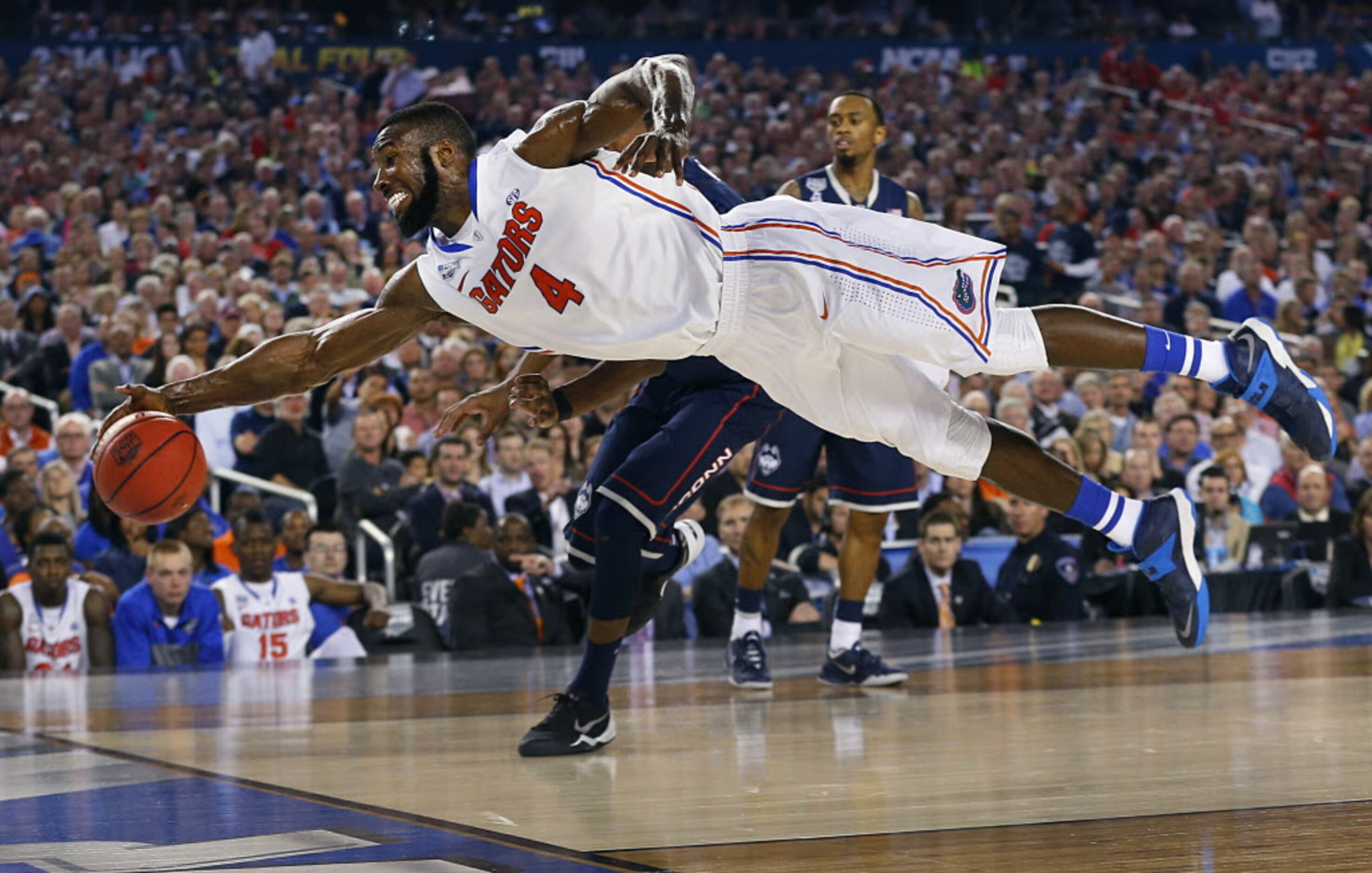 Florida Gators center Patric Young (4) dives for a loose ball going out of bounds against...