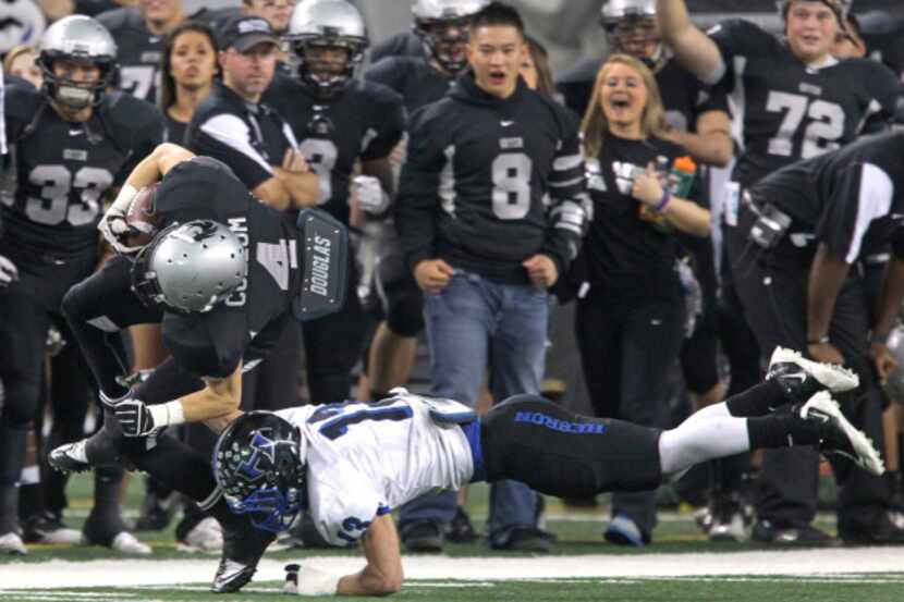 Denton Guyer's Lance Cullum (4) is cut down along the sideline after running with a pass...