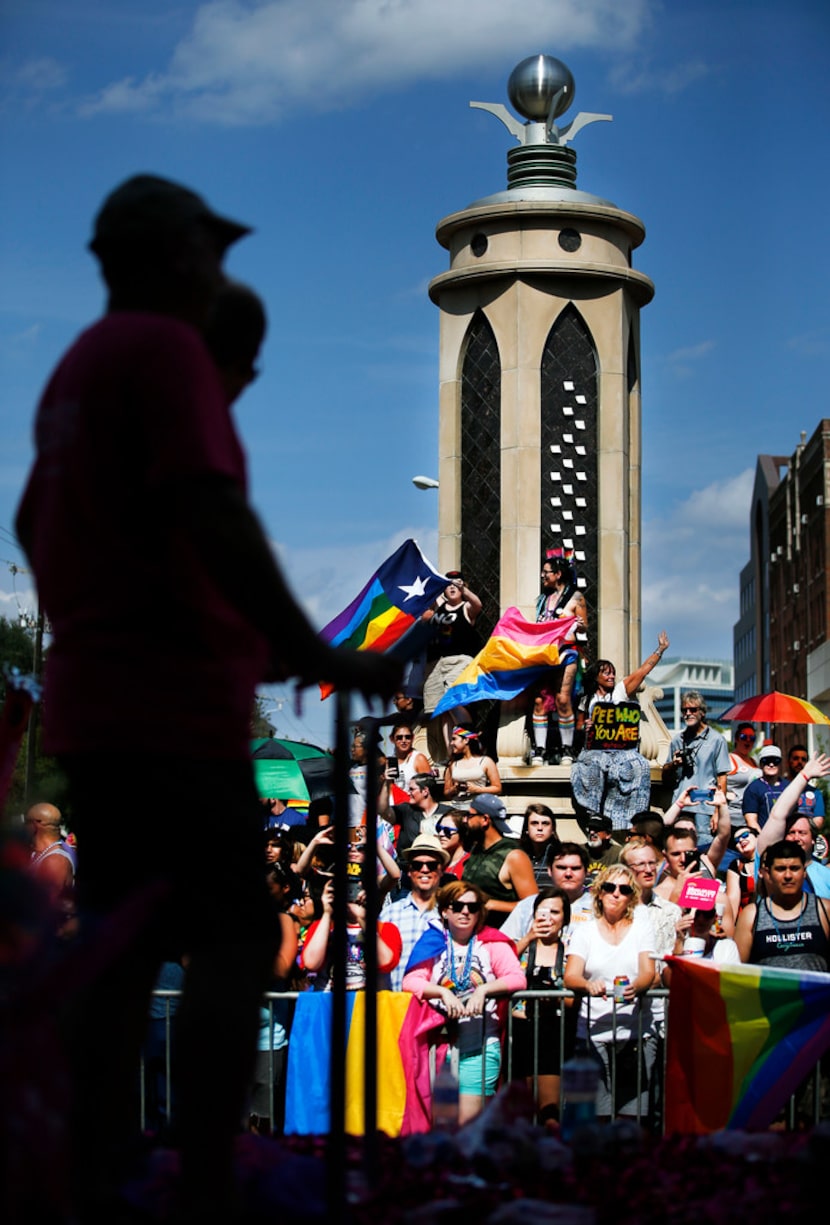 People view the Texas Freedom Parade from the Legacy of Love monument at Cedar Springs Rd....