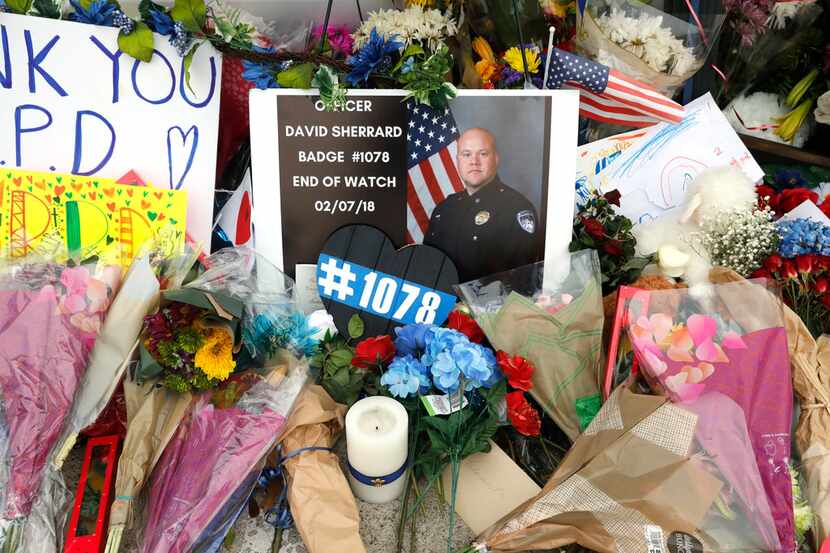 Flowers and other items were placed on a police cruiser at the Richardson police...