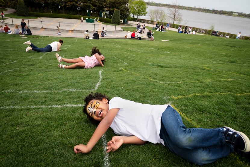 Kaniel Williams, 5, of Austin, rolls down a hill with his cousin Isadora Peña, 6, and mother...