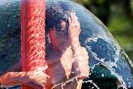 Swayze Arrendeol, 8, cools off under a water fountain, on Friday, June 14, 2024, at...