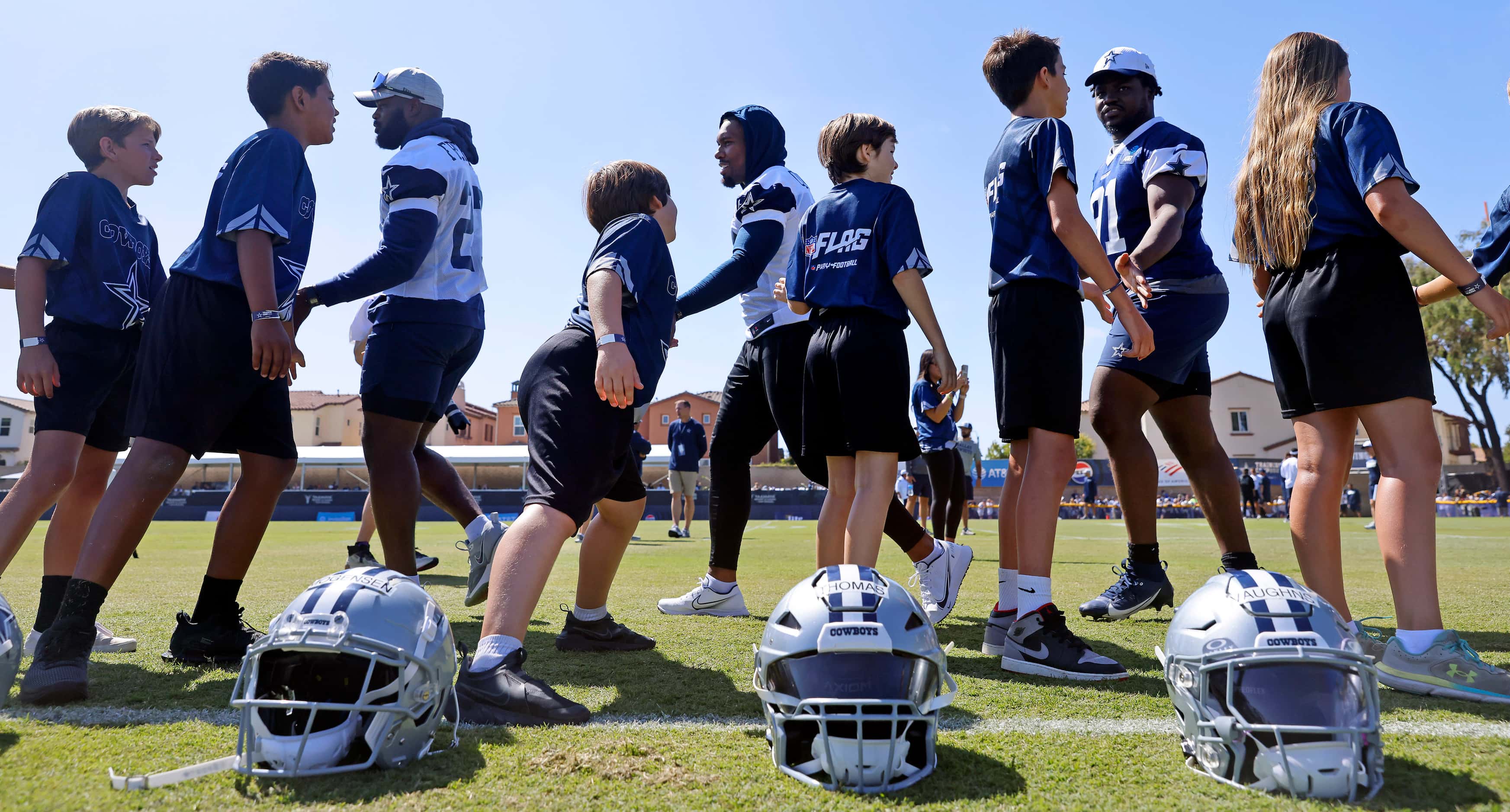 Youth NFL Flag Football players from Ventura County slap hands with Dallas Cowboys players...