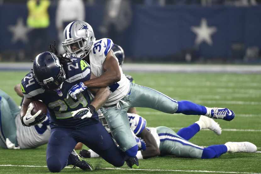 Seattle Seahawks running back Marshawn Lynch (24) is tackled by Dallas Cowboys cornerback...