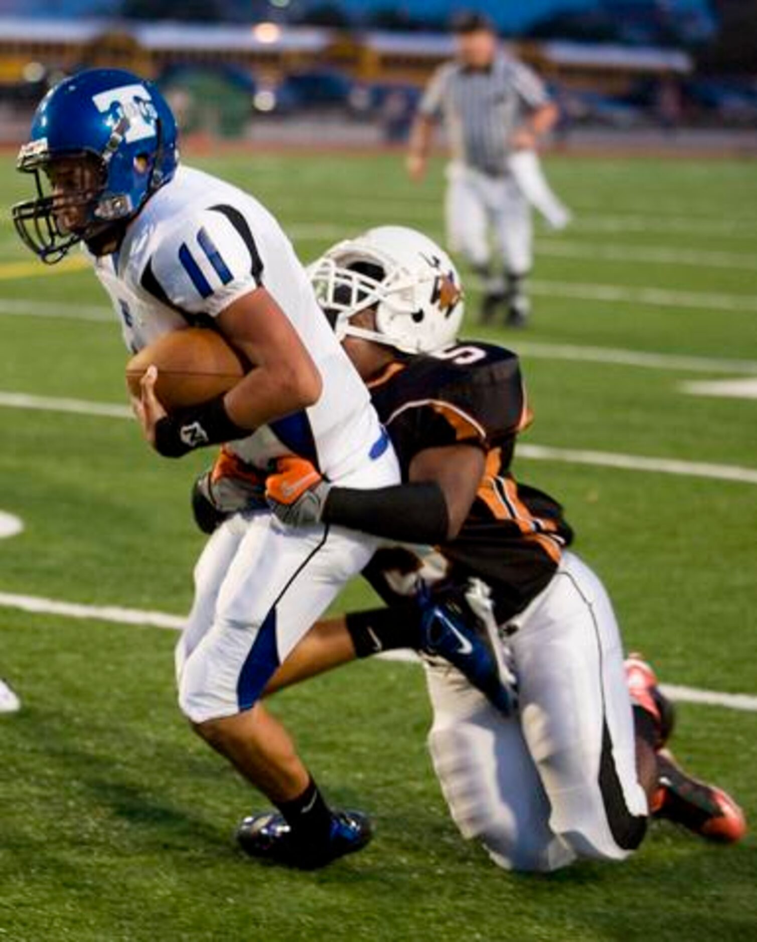 R.L. Turner junior Pedro Galvan (11) is tackled by W.T. White junior linebacker Quieontrey...