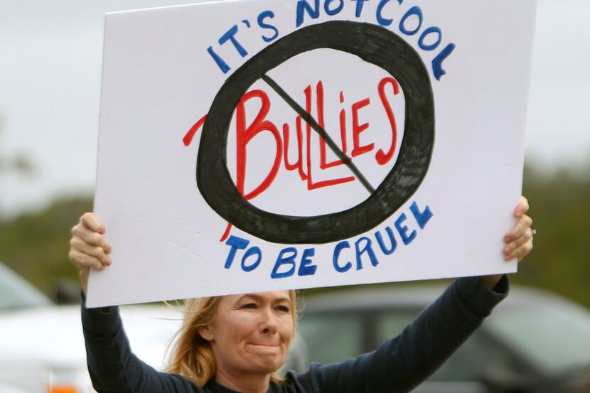 In this Monday, Jan. 22, 2018 photo, Dawn Graff holds a sign to protest bullying with other...