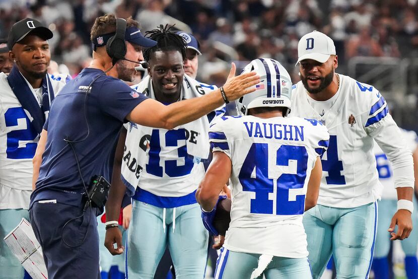 Dallas Cowboys running back Deuce Vaughn (42) celebrates with offensive coordinator Brian...
