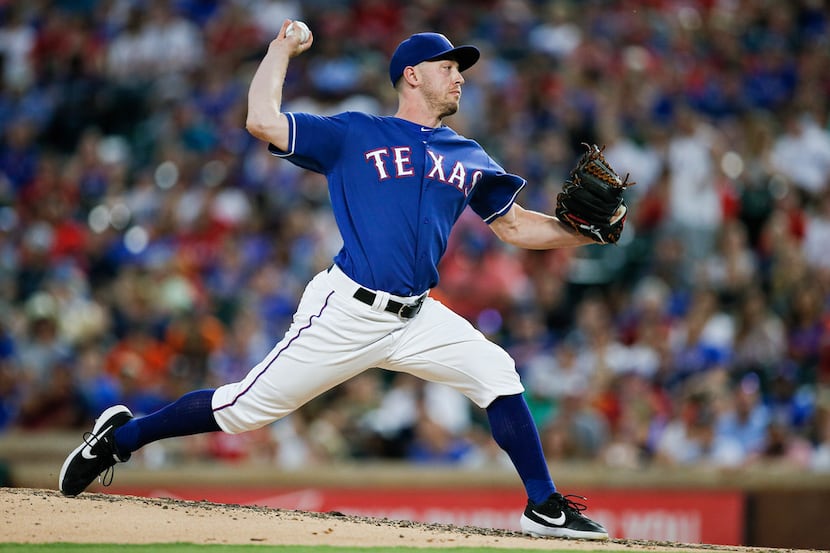 Texas Rangers' Adrian Sampson (52) thorws during the sixth inning of a baseball game against...