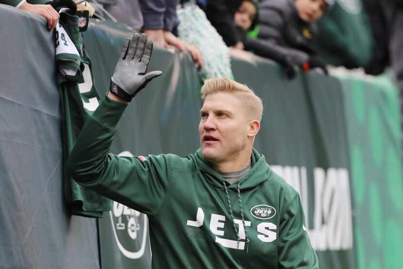 EAST RUTHERFORD, NJ - DECEMBER 24: Josh McCown #15 of the New York Jets high fives the fans...
