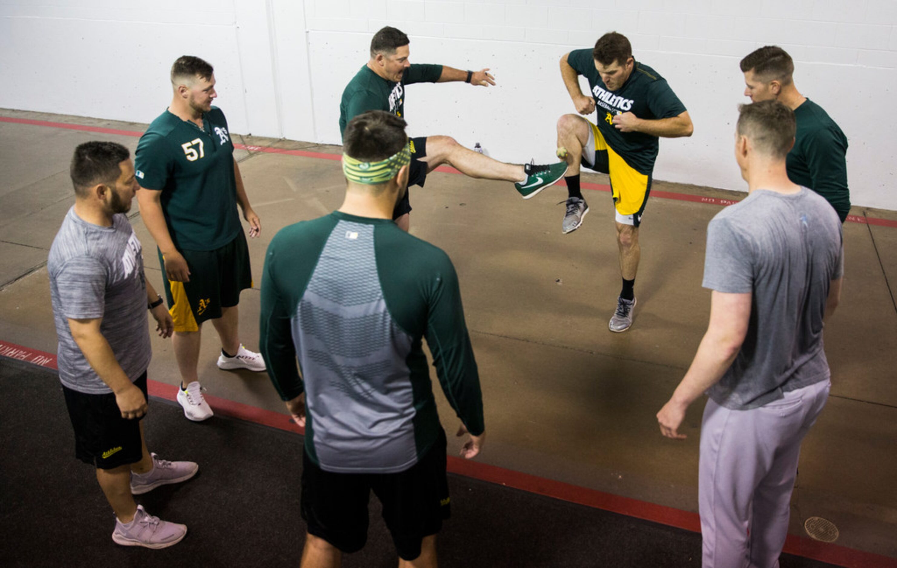 Oakland Athletics players play hacky sack in the tunnel during a rain delay at an MLB game...