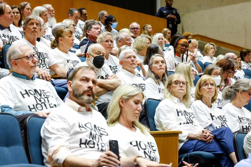A large portion of the audience wears white shirts that read, “homes not hotels,” during...